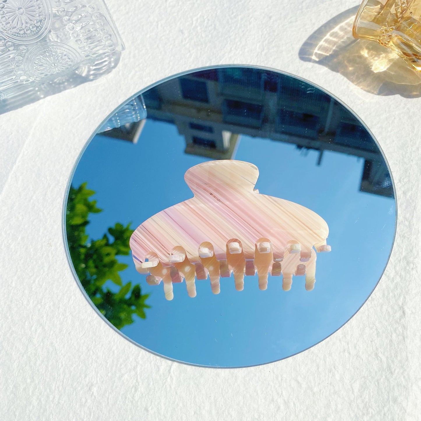 Striped pink hair claw clip on round mirror, blue sky reflection, FashionRay trendy accessory