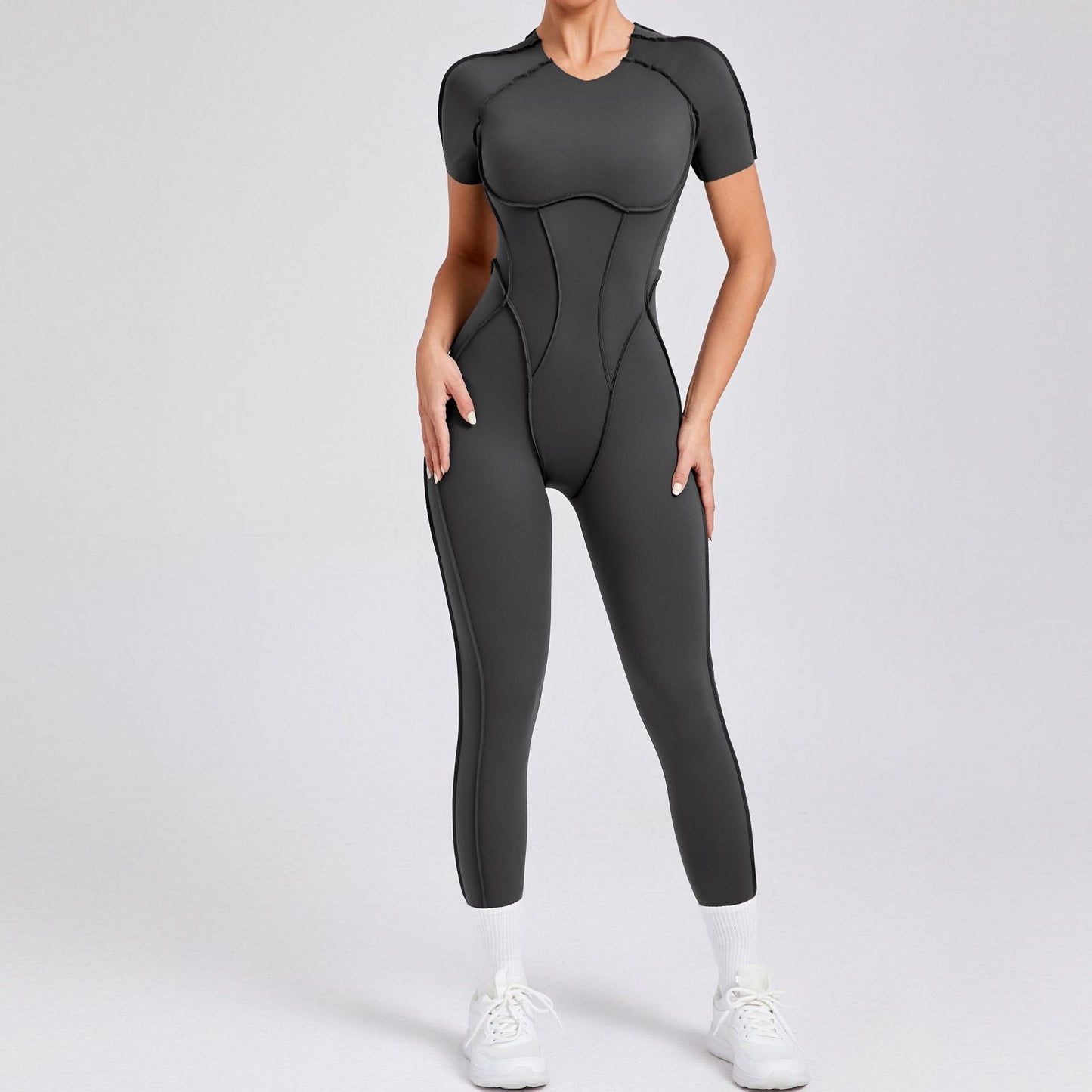 Woman wearing a fitted black jumpsuit and white sneakers, FashionRay trendy athleisure style