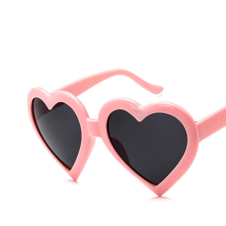 Pink heart-shaped sunglasses with black lenses on white background, FashionRay trendy accessory