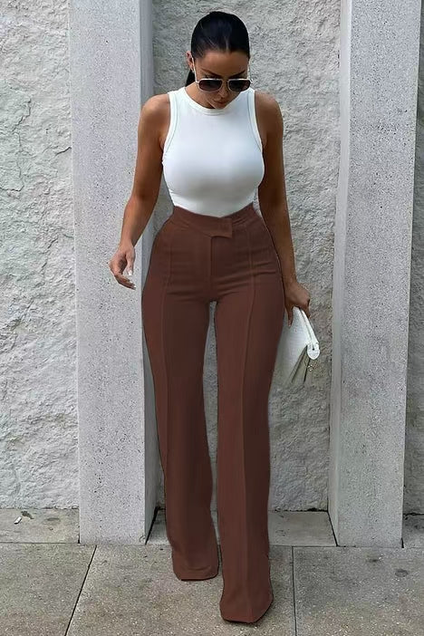 Woman in white sleeveless top and high-waisted brown pants holding clutch, FashionRay style