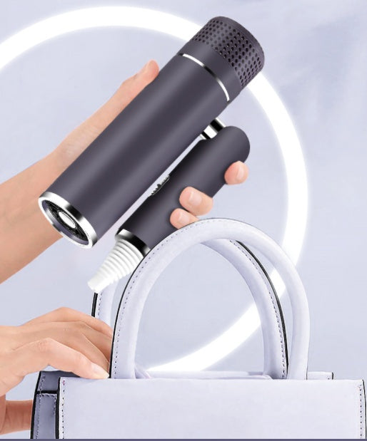 Portable handheld vacuum cleaner cleaning a stylish white handbag, FashionRay lifestyle