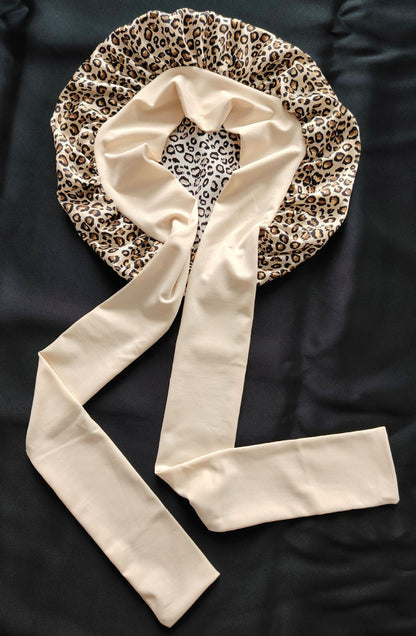 Leopard print satin bonnet with beige tie straps on black fabric, FashionRay accessory