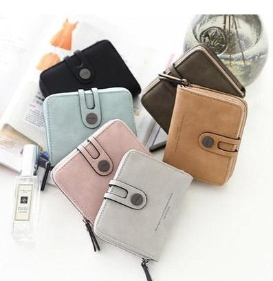 Assorted stylish wallets in pastel and neutral colors on a white table, FashionRay accessories