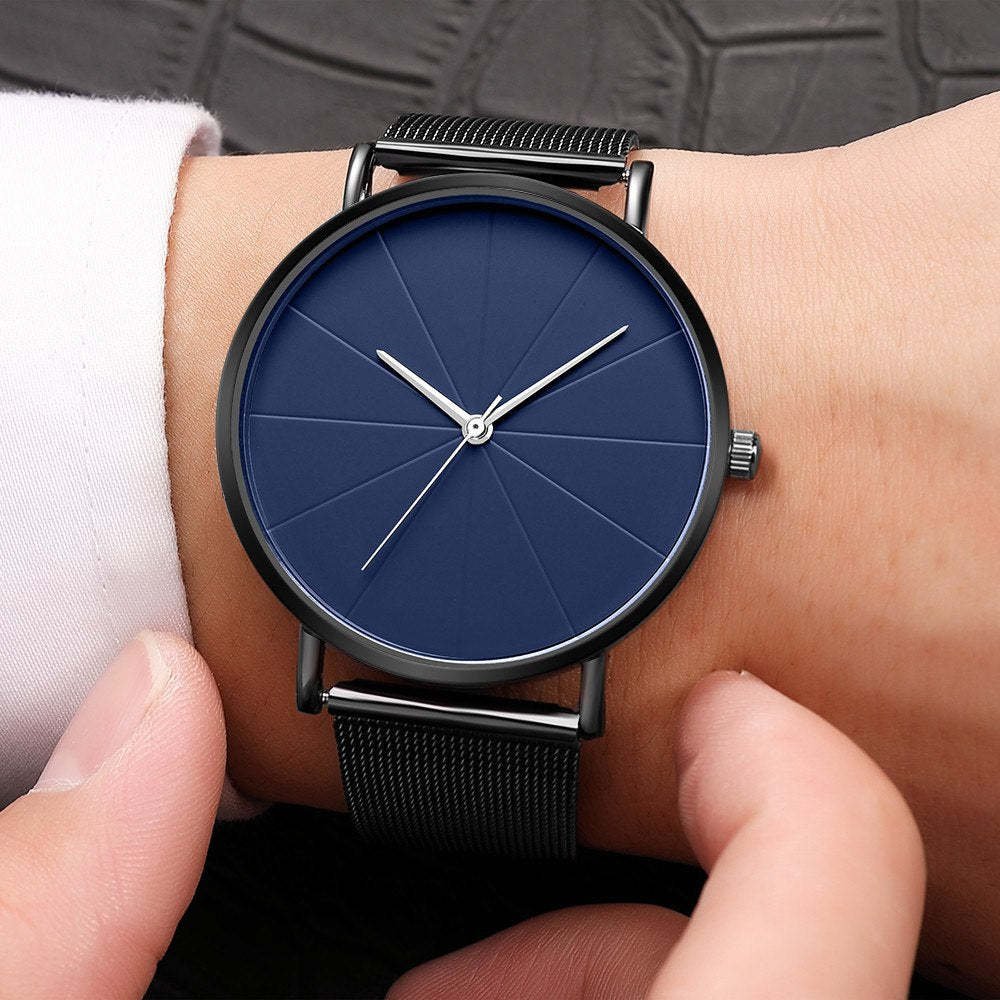 Minimalist blue analog wristwatch with black mesh band on wrist, FashionRay style