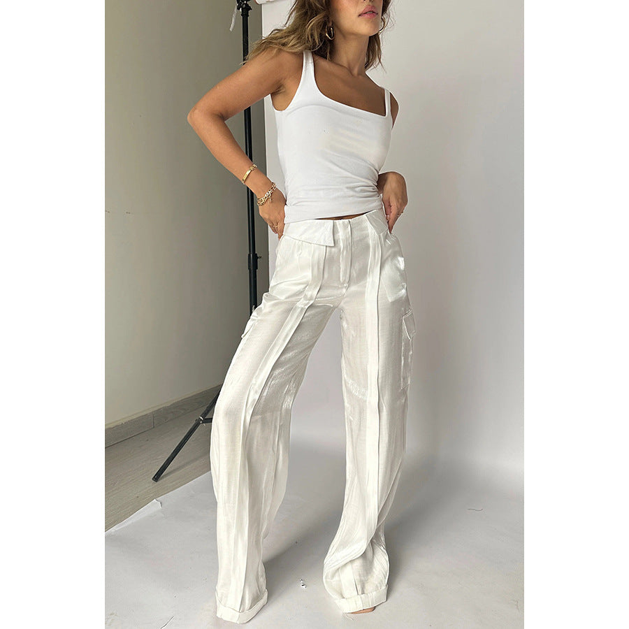 Woman modeling trendy white tank top and wide-leg satin pants in minimalist studio, FashionRay