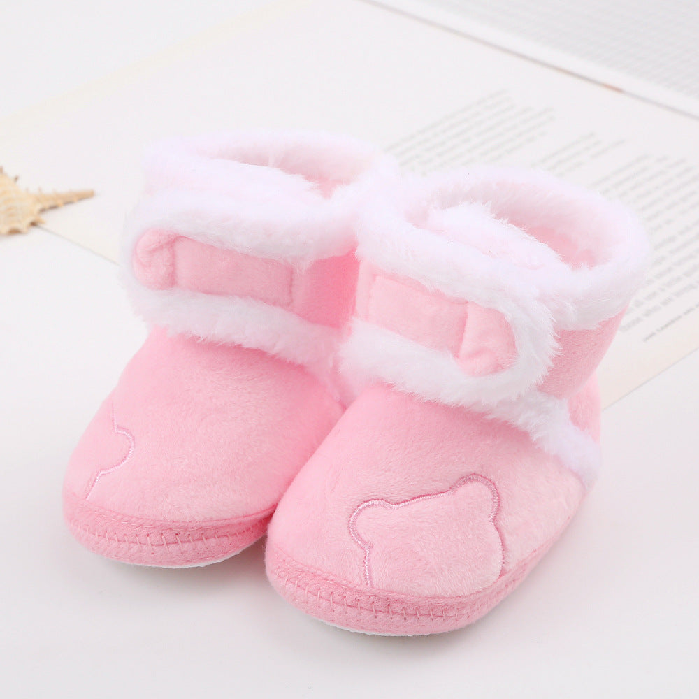 Pink plush baby booties with white faux fur trim, bear face embroidery, on FashionRay