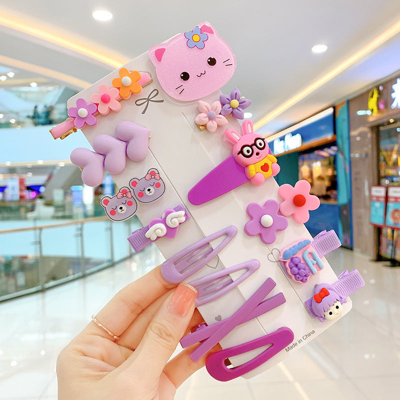 Hand holding a set of cute purple and pink cartoon hair clips and barrettes at FashionRay mall