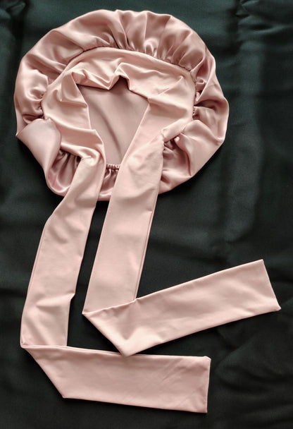Light pink satin bonnet with long ties on black fabric, FashionRay trendy sleepwear accessory