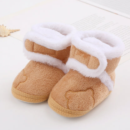 Fuzzy tan baby booties with white lining and bear face detail on FashionRay