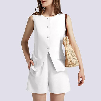 Woman in sleeveless white buttoned top and shorts, holding a beige lace shoulder bag, FashionRay style
