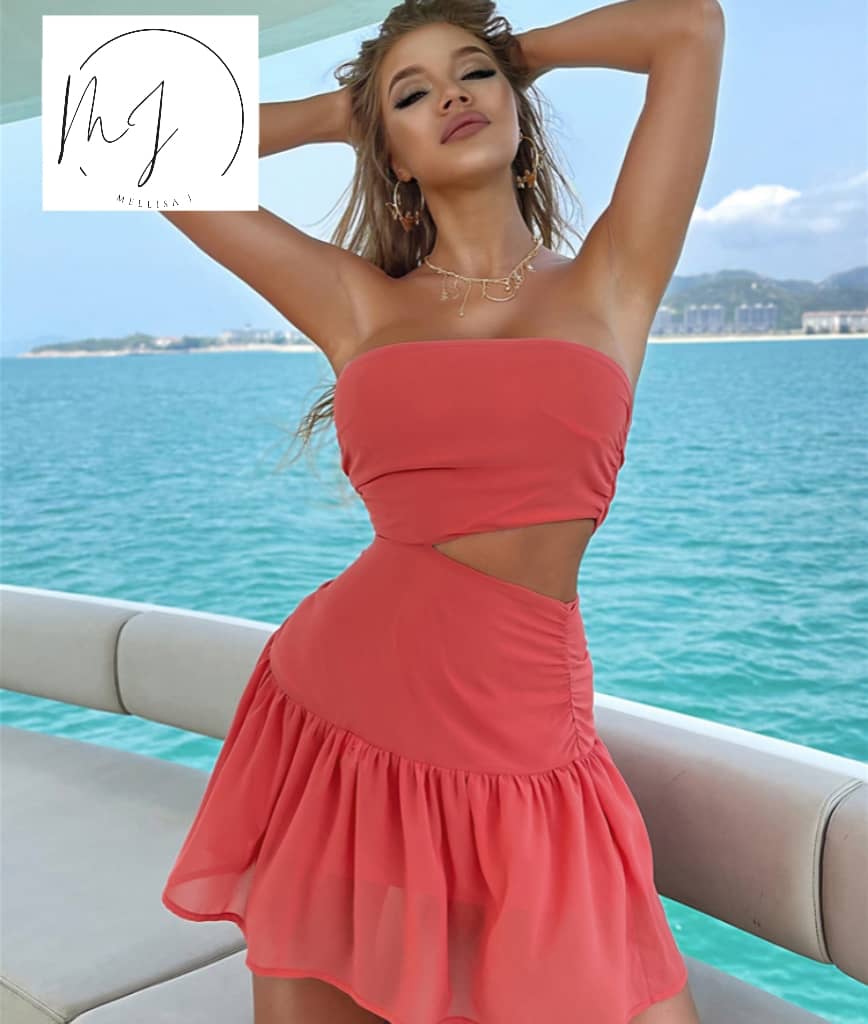Woman in coral cutout dress posing on yacht with ocean view, trendy summer fashion from FashionRay