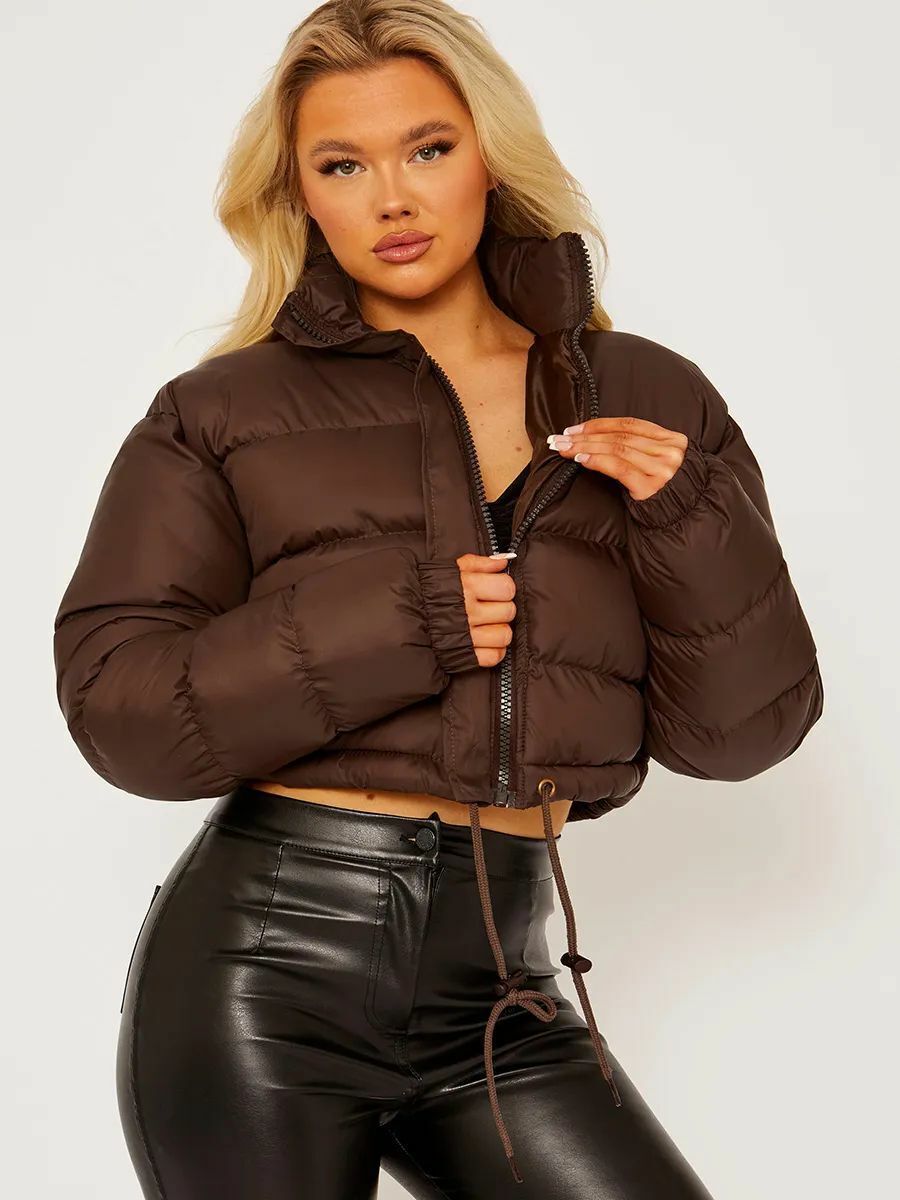 Woman modeling a brown puffer jacket and black faux leather pants, FashionRay style