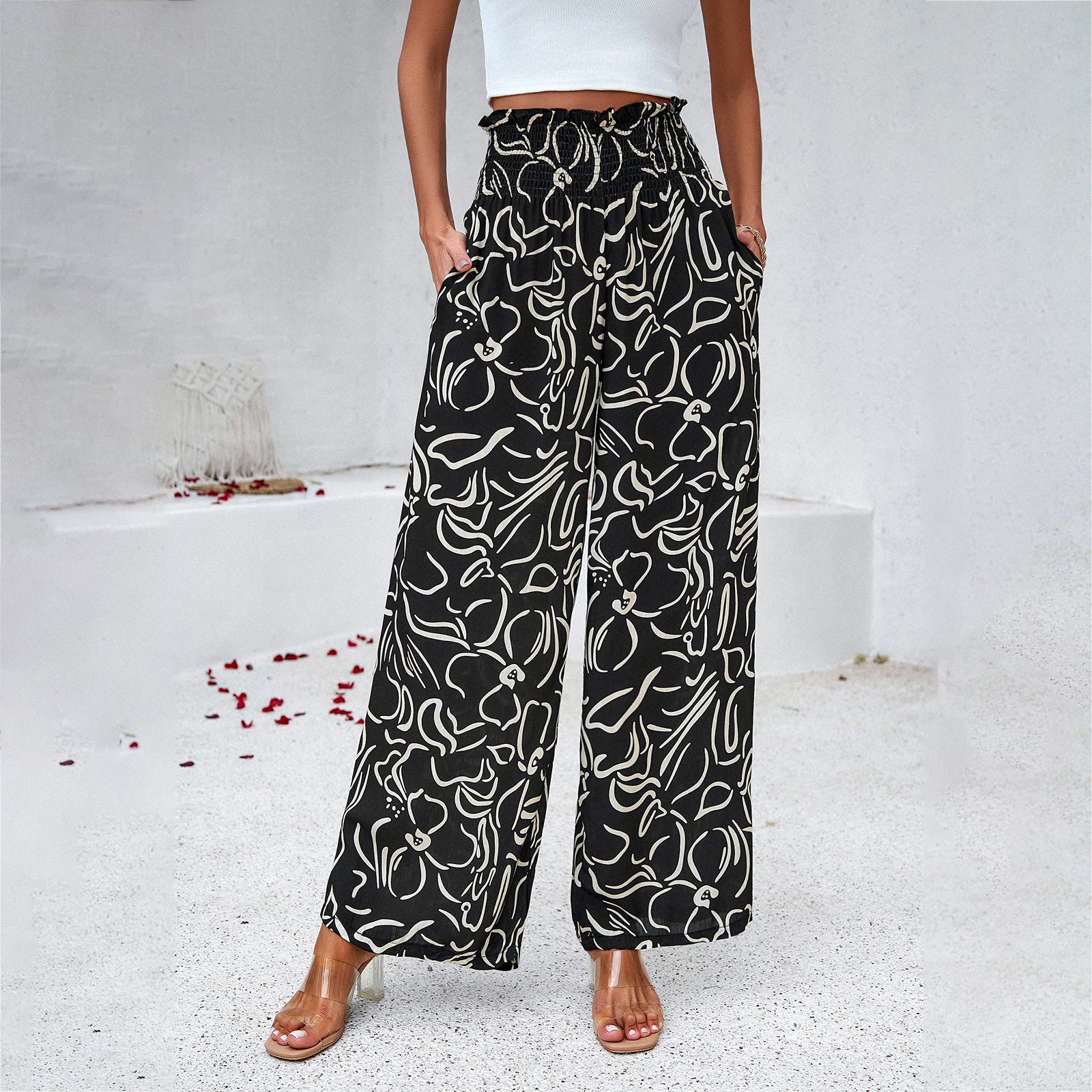 Woman wearing black wide leg floral print pants and white crop top from FashionRay