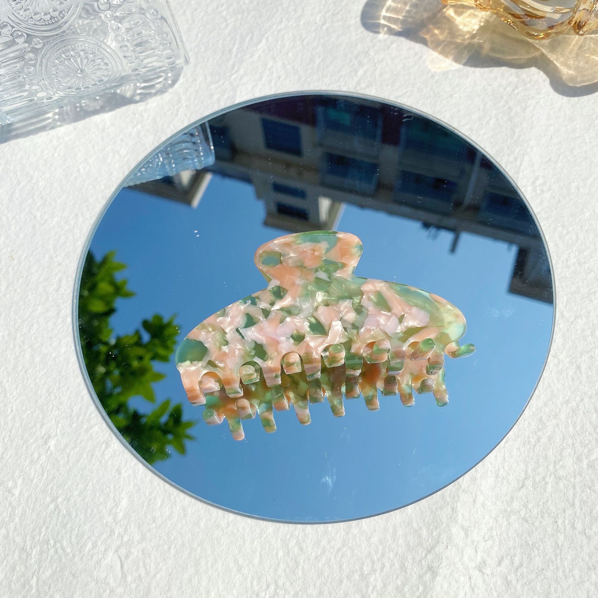 Pastel marble hair claw clip on round mirror, FashionRay accessories in natural sunlight