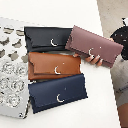 FashionRay trendy moon and star wallets in black, brown, navy, and mauve on table