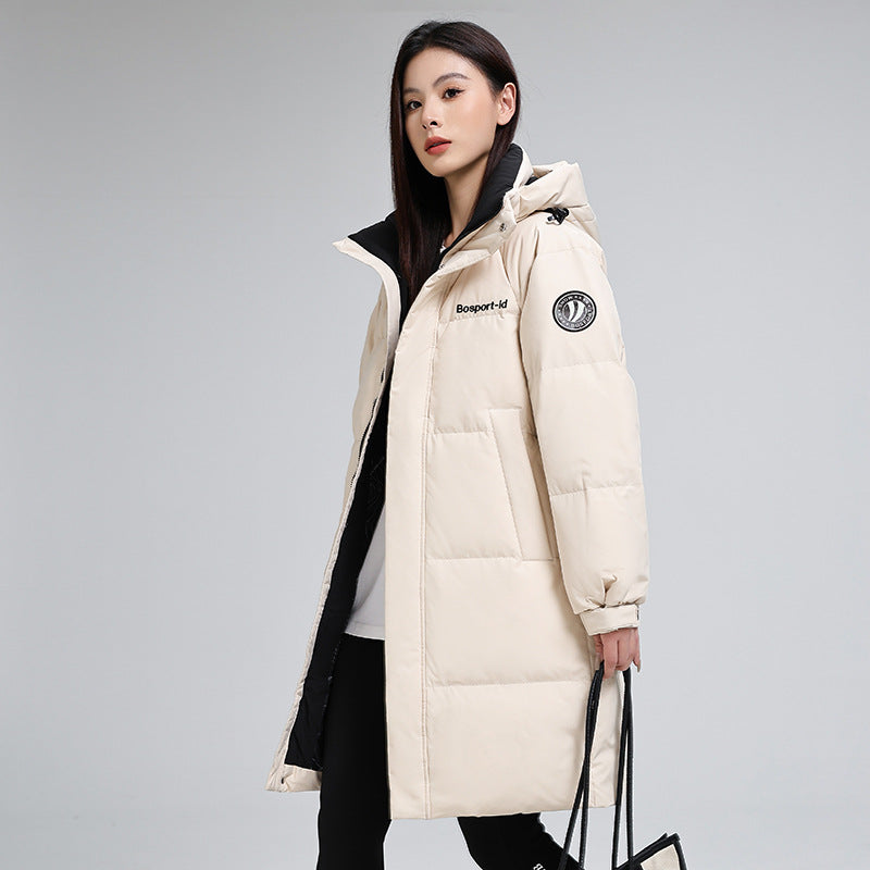 Woman in cream puffer coat with hood, holding tote bag, FashionRay trendy outerwear