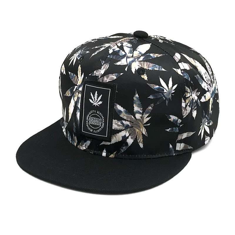 Black snapback hat with bold leaf print and front patch, trendy streetwear from FashionRay.