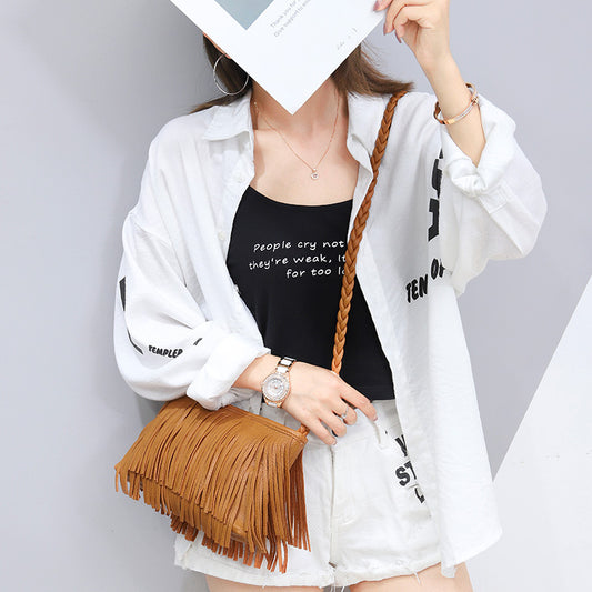 Woman in white shirt, black tank top, white shorts, and tan fringe bag, FashionRay style