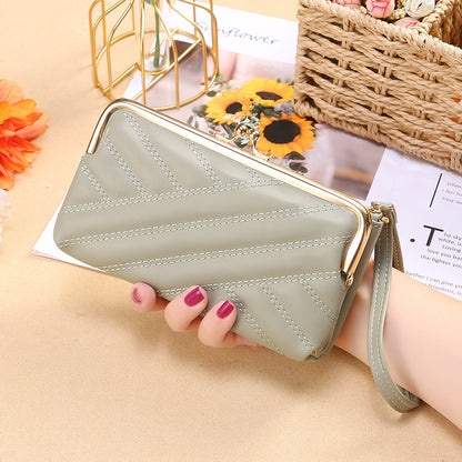 Hand holding a stylish light green quilted clutch wallet with wrist strap, FashionRay accessory
