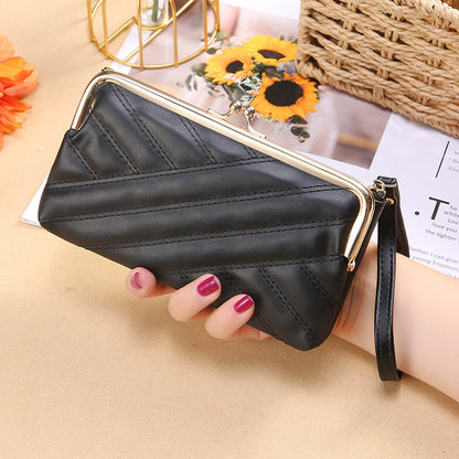 Woman holding a black quilted clutch wallet with gold frame clasp, trendy FashionRay accessory