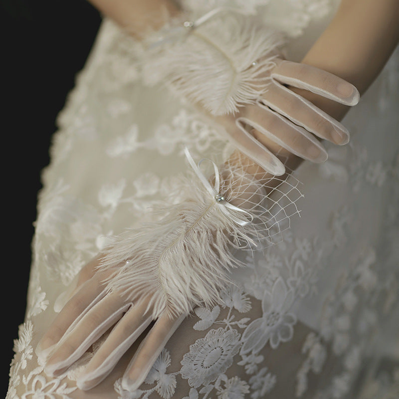 Elegant sheer lace gloves with feather trim and ribbon, perfect for bridal or vintage fashion by FashionRay