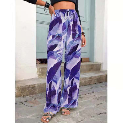 Woman wearing wide-leg purple leaf print pants and sandals, standing outdoors, FashionRay style