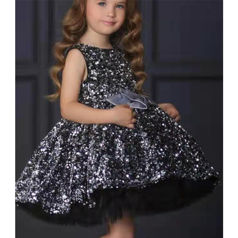 Girl wearing a sparkly black sequin dress with a silver bow, FashionRay trendy kids fashion