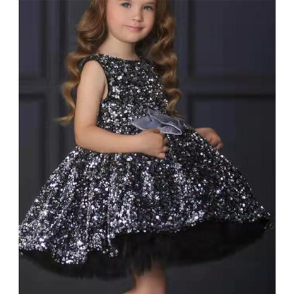 Girl wearing a sparkly black sequin dress with a silver bow, FashionRay trendy kids fashion