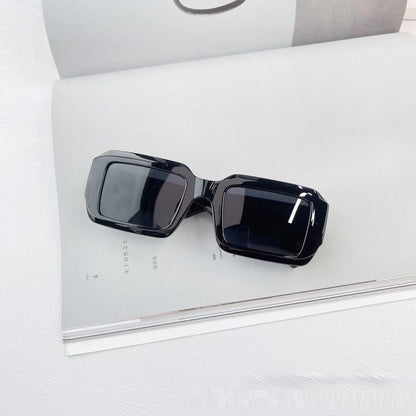 Trendy black rectangular sunglasses on an open magazine, FashionRay bold eyewear style