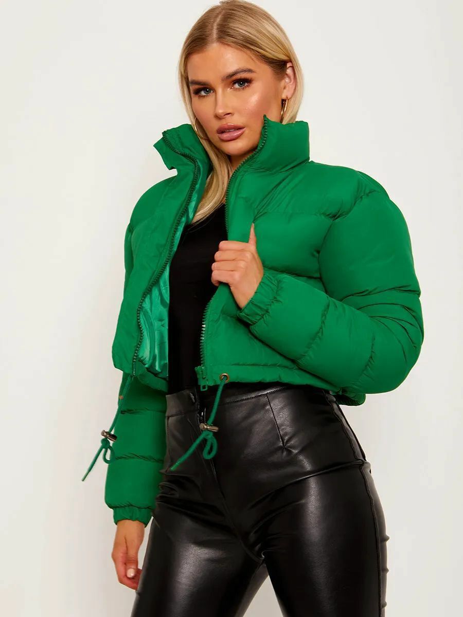 Woman modeling trendy green puffer jacket and black leather pants, FashionRay bold style