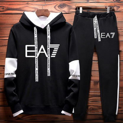 Black EA7 hoodie and jogger set with white accents, displayed on wooden background, FashionRay style.