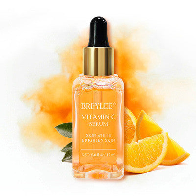 BREYLEE Vitamin C serum bottle with dropper, fresh orange slices, and bold orange splash, skincare product