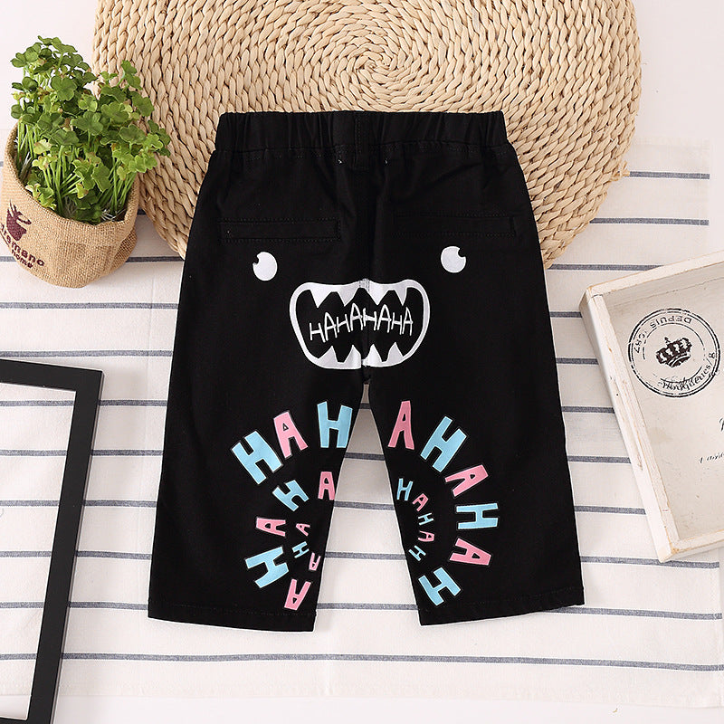 Black kids shorts with playful monster face and colorful 'HAHA' print, FashionRay style