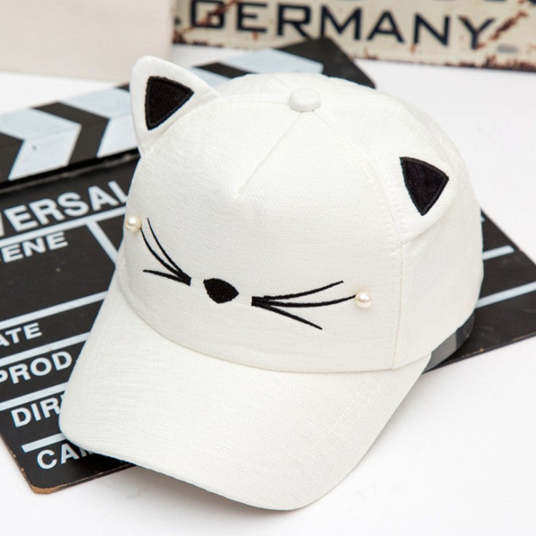 White cat ear cap with embroidered face, trendy kawaii hat from FashionRay on a film slate