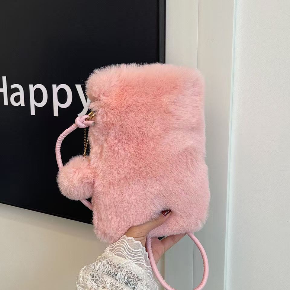 Hand holding a fluffy pink faux fur crossbody bag with pom-pom, FashionRay trendy accessory