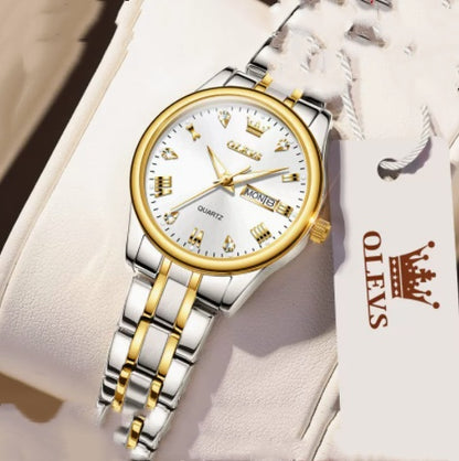 Silver and gold men's quartz wristwatch with date display, showcased on cushion, OLEVS tag attached