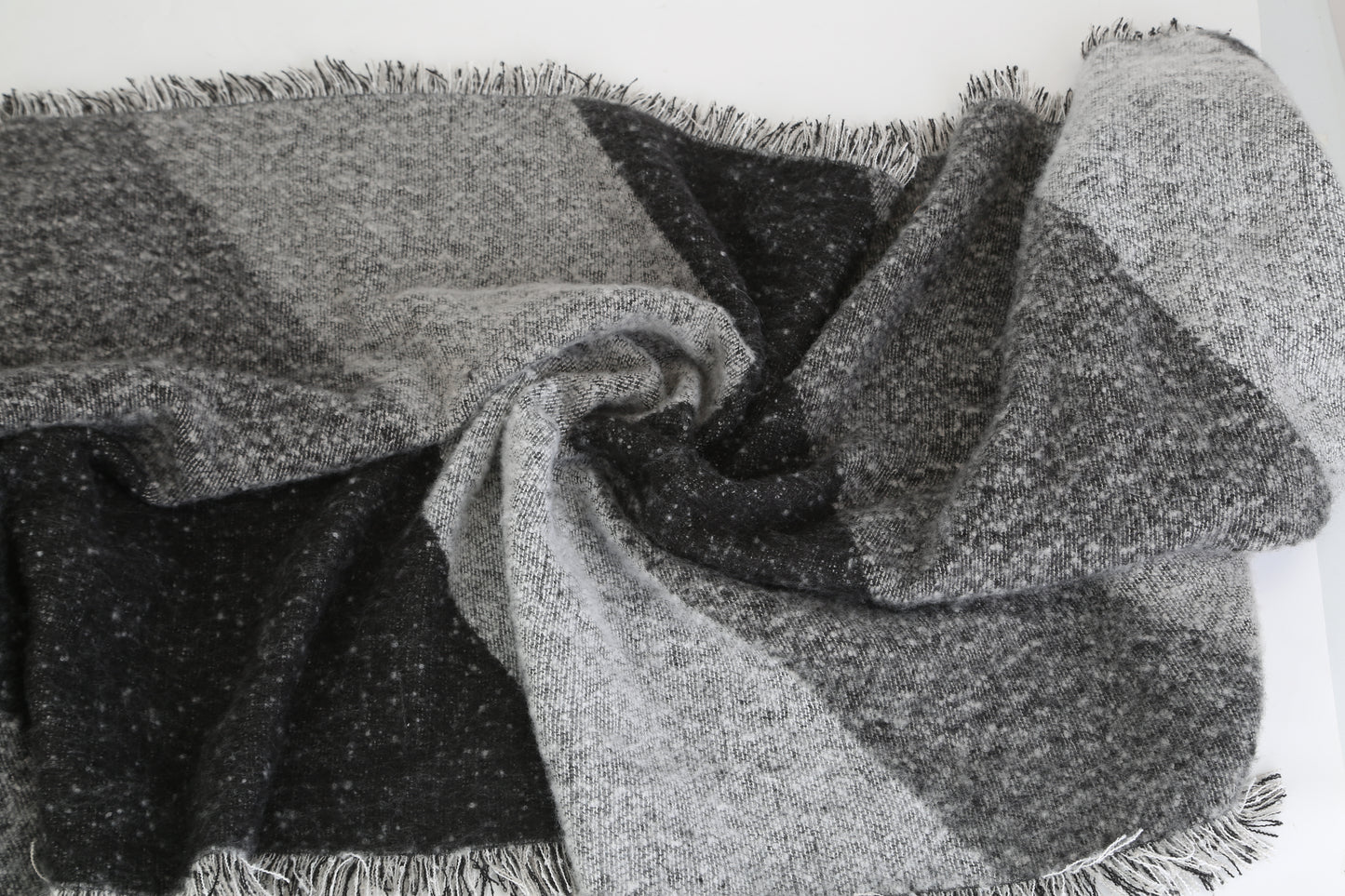 Cozy black and grey checkered scarf with fringe edges, soft texture from FashionRay