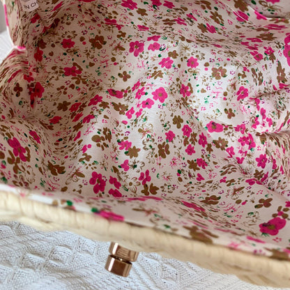 Interior of a FashionRay bag with pink and brown floral fabric lining on white background