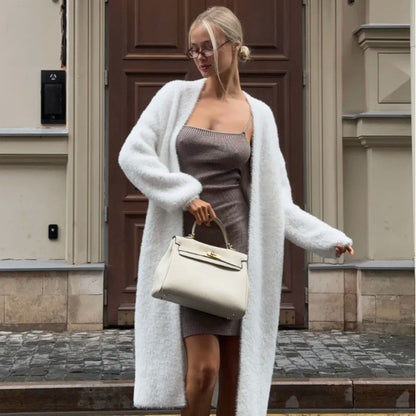 Woman in stylish ribbed dress and fuzzy white cardigan holding a cream handbag, FashionRay look