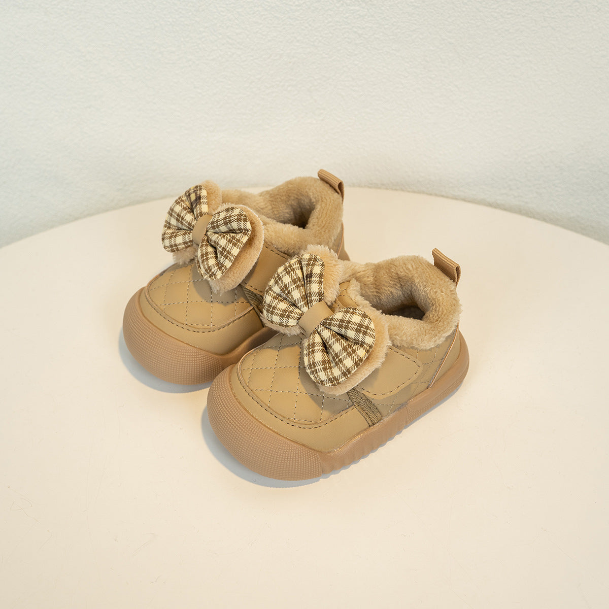 Beige quilted toddler shoes with plaid bows and faux fur lining from FashionRay.