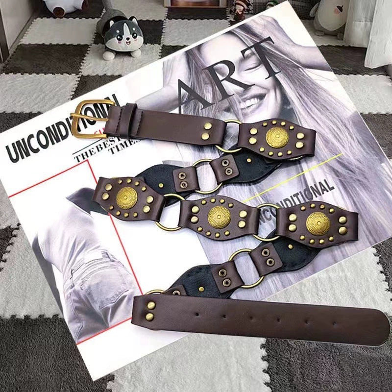 Brown fashion belt with gold stud accents on a magazine, trendy accessory by FashionRay.