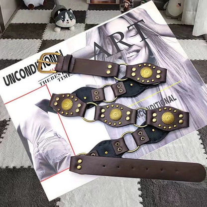 Brown fashion belt with gold stud accents on a magazine, trendy accessory by FashionRay.