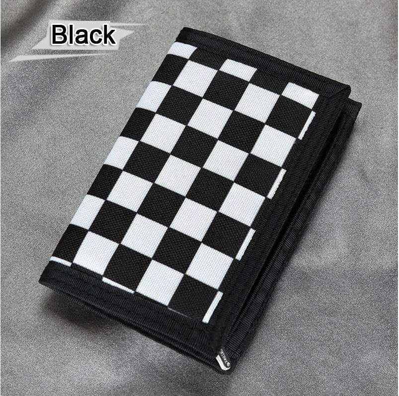 Black and white checkered wallet on gray fabric, trendy accessory at FashionRay