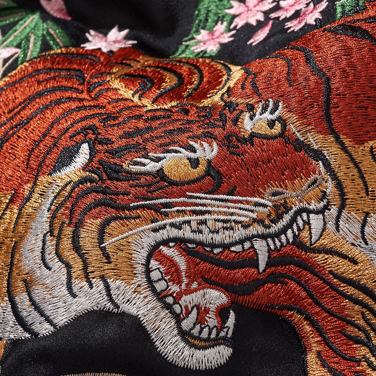 Detailed embroidered tiger head on black fabric with floral accents, FashionRay bold style