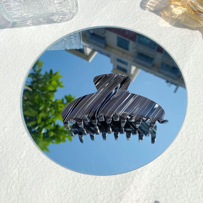 Striped black hair claw clip on round mirror with urban background, FashionRay accessory