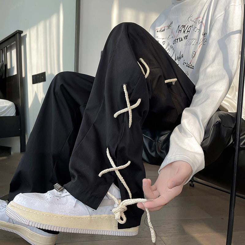 Trendy black pants with white rope details and white sneakers, casual modern fashion style
