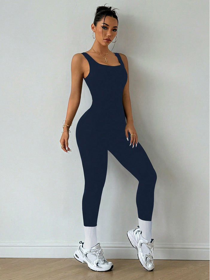 Woman modeling a navy blue sleeveless jumpsuit with sneakers, stylish activewear FashionRay