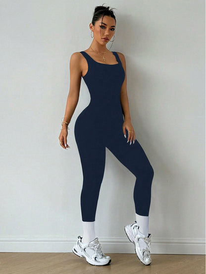 Woman modeling a navy blue sleeveless jumpsuit with sneakers, stylish activewear FashionRay