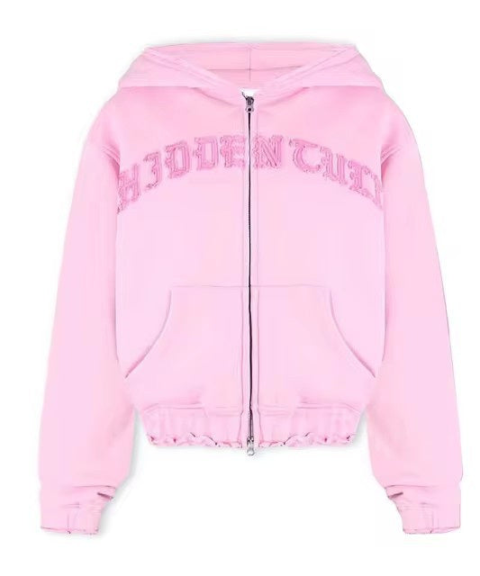 Light pink zip-up hoodie with 'HIDDEN' textured letters, kangaroo pocket, and hood, FashionRay style
