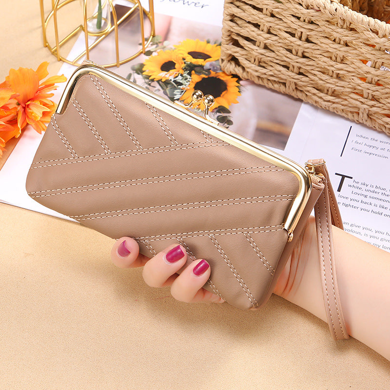 Woman holding beige leather clutch wallet with gold clasp, FashionRay trendy accessory